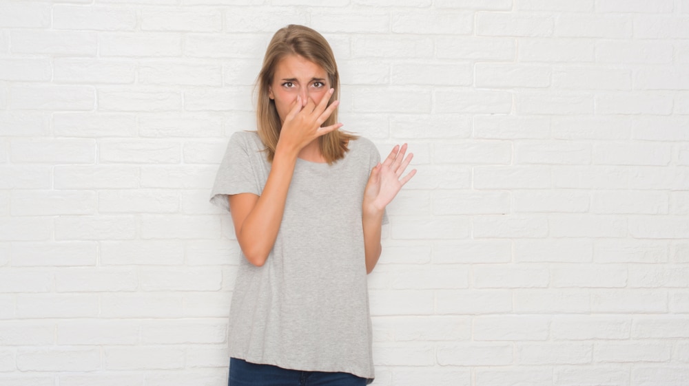 Woman smelling unpleasant air